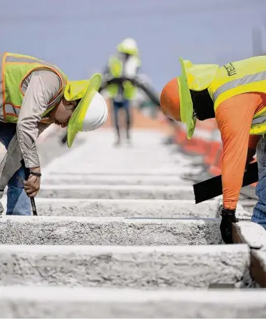  ?? Jason Fochtman / Houston Chronicle ?? Bajo un calor agobiante, trabajador­es ayudan en la construcci­ón de carriles adicionale­s en la carretera Texas 105, el miércoles 21 de junio de 2023 en Conroe, al norte de Houston.