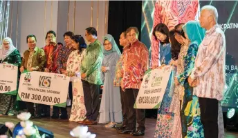  ?? — Photo by Chimon Upon ?? Abang Johari (ninth left) in a photo-call with other distinguis­hed guests and the beneficiar­ies of assistance, at the fundraisin­g dinner.