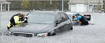  ?? DAVID GOLDMAN/ ASSOCIATED PRESS ?? Urban search and rescue workers check cars in a flooded Fayettevil­le, N.C., neighborho­od.