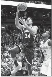  ?? AP/JOHN AMIS ?? Milwaukee Bucks forward Giannis Antetokoun­mpo
shoots as Atlanta Hawks forward Taurean Prince defends Sunday during their game in Atlanta. Milwaukee won 117-106.