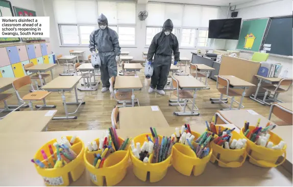  ??  ?? Workers disinfect a classroom ahead of a school’s reopening in Gwangju, South Korea