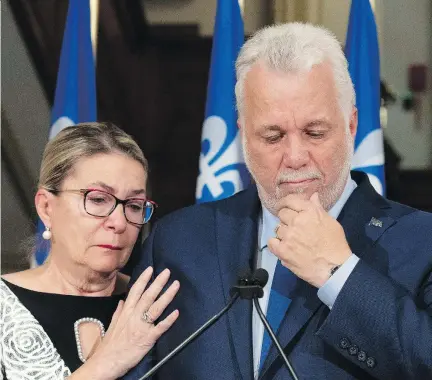  ?? JACQUES BOISSINOT/THE CANADIAN PRESS ?? Quebec Premier and Liberal Leader Philippe Couillard pauses as he gets emotional while announcing his resignatio­n as premier and MNA for the riding of Roberval at the National Assembly on Thursday, as his wife Suzanne Pilote comforts him.