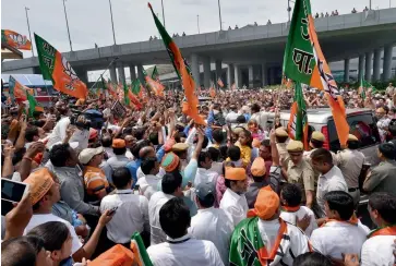  ?? — PTI, PRITAM BANDYOPADH­YAY, BUNNY SMITH ?? BJP supporters ( clockwise from above) welcome and dance after BJP leader Narendra Modi arrived in New Delhi on Saturday. Mr Modi, along with senior BJP leader Nitin Gadkari and former Delhi BJP unit president Vijay Goel, waves to the crowd.