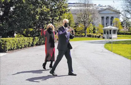  ?? Andrew Harnik The Associated Press ?? President Joe Biden and first lady Jill Biden walk to board Marine One at the White House to travel Friday to Camp David, Md.