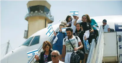  ??  ?? NEW ISRAELIS from France disembark at Ben-Gurion Airport on July 20.