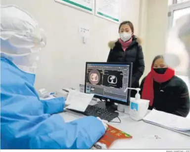  ?? WANG YANBING / EFE ?? Un doctor observa las pruebas realizadas a una paciente en un centro médico de la provincia china de Shandong.