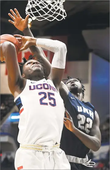  ?? Jessica Hill / Associated Press ?? UConn’s Josh Carlton (25) goes up to the basket as New Hampshire’s David Watkins defends on Satruday.