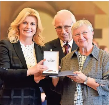  ?? FOTO: ANDRIŠEK (ARCHIV) ?? Die kroatische Ministerpr­äsidentin Kolinda Grabar-Kitarovic (l.) ehrte Ende Juni 2019 den für seine Bosnienhil­fe bekannten Heribert Hölz zusammen mit seiner Frau Ursula.