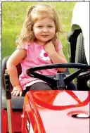  ??  ?? Kaitlyn Ruttan, 2, of Bella Vista, sits in the seat of a lawnmower at the show on Friday.