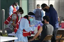  ?? MARCIO JOSE SANCHEZ — THE ASSOCIATED PRESS FILE ?? Health care workers receive a COVID-19 vaccinatio­n at the Ritchie Valens Recreation Center in Pacoima on Wednesday.