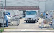  ?? Kyle Grillot / Getty Images ?? Postal workers sort and load mail Aug. 22 in Los Angeles. States are seeing record-breaking interest in mail-in voting during the coronaviru­s pandemic.