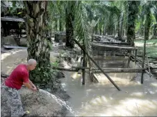 ?? ?? Mukhtar put water from Gunung Tebu into his catfish pond in Felda Selasih.