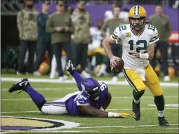  ?? BRUCE KLUCKHOHN — THE ASSOCIATED PRESS ?? Packers quarterbac­k Aaron Rodgers runs from Vikings defensive tackle Dalvin Tomlinson during their game on Sunday.