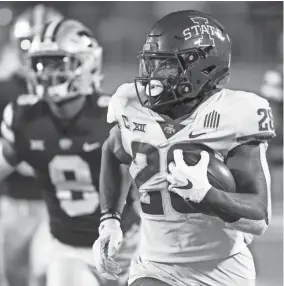  ?? COLIN E. BRALEY/AP ?? Iowa State running back Breece Hall (28) rushes for a first down as he is chased by Kansas State defenders during the fourth quarter of Saturday’s game in Manhattan, Kan.