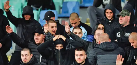  ??  ?? Nazi salutes: A gang of black-clad and shaven-headed Bulgaria supporters during Monday night’s game against England