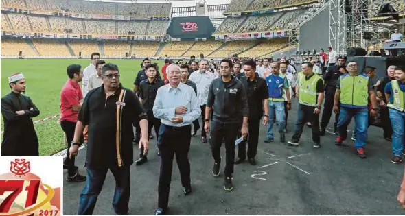  ?? PIC BY ASYRAF HAMZAH ?? Prime Minister Datuk Seri Najib Razak at the Bukit Jalil National Stadium yesterday. With him are Umno executive secretary Datuk Seri Abdul Rauf Yusoh (left) and Youth and Sports Minister Khairy Jamaluddin (third from left).