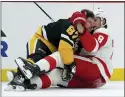  ?? MATT FREED — THE ASSOCIATED PRESS ?? Penguins star Sidney Crosby, left, and the Red Wings' Ben Chiarot mix it up during a crucial game in the Eastern Conference playoff race on Thursday night.