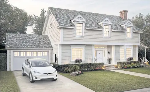  ?? TESLA INC VIA AP ?? This photo provided by Tesla Inc shows a house with the company’s new slate solar roof tiles.