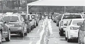  ?? KEVIN RICHARDSON/BALTIMORE SUN ?? People wait for their COVID-19 vaccines in cars lined up last month at the mass vaccinatio­n site at Six Flags America in Upper Marlboro.