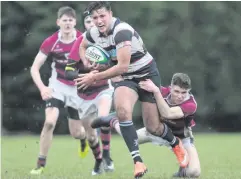  ??  ?? Gripping affair: Dungannon’s Lewis Connelly clashes with Wallace’s Ben Carson at the weekend