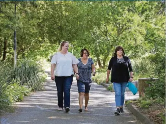  ?? RANDY PENCH/THE SACRAMENTO BEE ?? Kimberly Pearson, right, walks with her workmates, Courtney Kievernage­l, left, and Martha Garrison along a trail in the UC Davis Arboretum where they often take walks on April 24 in Davis, Calif. Pearson is fighting a deadly form of hepatitis that is sneaking up on millions of Americans. Her illness had progressed to the third of four stages by the time a physician diagnosed the Esparto resident with it.