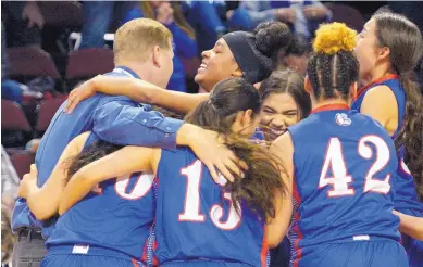  ?? GREG SORBER/JOURNAL ?? Las Cruces’ Janessa Johnson, rear, who hit the winning basket, hugs coach Matt Abney as the team celebrates its 6A quarterfin­als victory over Carlsbad at the Santa Ana Star Center on Tuesday night.