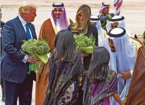  ?? AGENCY PIX ?? US President Donald Trump and First Lady Melania being welcomed on arrival in Riyadh yesterday. With them is Saudi Arabia King Salman Abdulaziz al-Saud.