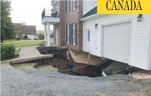  ?? PAUL MAYNARD/THE CANADIAN PRESS ?? A sinkhole appeared under this Falmouth, N.S., house on Sunday. Officials say the family is safe, but the building is expected to collapse soon.