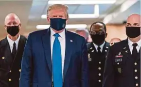  ?? AFP PIC ?? United States President Donald Trump wearing a face mask as he visited a military hospital in Bethesda on Saturday.