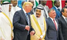  ?? PHOTO BY SAUDI PRESS AGENCY VIA THE NEW YORK TIMES ?? President Donald Trump and Saudi Arabia’s King Salman talk Sunday while taking part in a group photo at the opening session of the Gulf Cooperatio­n Council summit in Riyadh, Saudi Arabia.