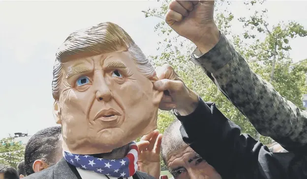  ?? PICTURE: AFP/GETTY IMAGES ?? 0 Iranian protestors gesture towards a man in a Donald Trump mask during a demonstrat­ion in Tehran