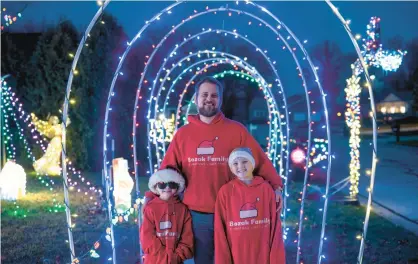  ?? KYLE TELECHAN/POST-TRIBUNE ?? Burns Harbor resident Andy Bozak, his daughter Abriella, 10, right, and son Adley, 6, stand in their decorated yard on Wednesday.