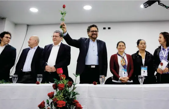  ?? FOTO ?? Iván Márquez, quien fue el jefe negociador de las Farc, levanta una rosa roja, que es, además, el símbolo del naciente partido político. En la mesa está acompañado por miembros del Secretaria­do y mujeres de la organizaci­ón.