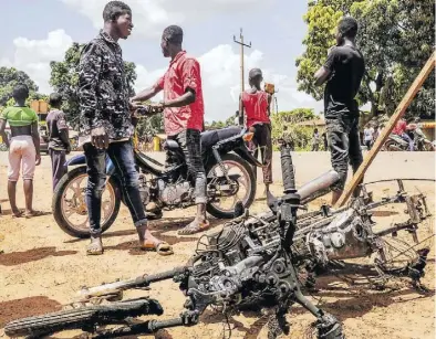  ?? AP-BILD: Souici ?? Vor den Wahlen in Guinea kam es zu Ausschreit­ungen, mindestens 30 Menschen starben. Auf dem Bild ein verbrannte­s Motorrad eines Anhängers der Opposition.
