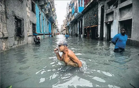  ?? YAMIL LAGE / AFP ?? Un cubano cruza una calle inundada del centro de La Habana