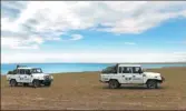  ?? PHOTOS BY WANG ZHUANGFEI / CHINA DAILY ?? A volunteer picks up trash that travelers discard in Hoh Xil, Qinghai province. Right: Two police vehicles patrol in Hoh Xil.