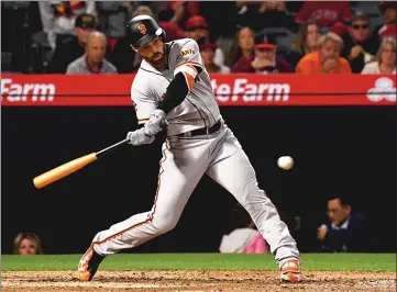  ??  ?? The San Francisco Giants’ Mac Williamson connects for a two-run homer during the fifth inning of Friday night’s game against the Angels in Anaheim. Williamson’s home run in his season debut gave the Giants a 3-0 lead, and Jeff Samardzija struck out...