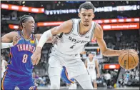  ?? Darren Abate The Associated Press ?? Spurs center Victor Wembanyama drives past Thunder forward Jalen Williams during San Antonio’s win Thursday at Frost Bank Center.