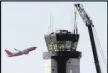  ?? Las Vegas Review-Journal ?? Workers prepare to lift a cab from the top of an old tower at McCarran.