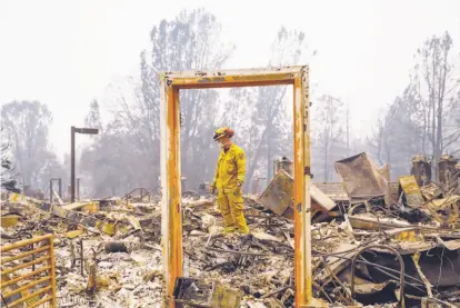  ?? Gabrielle Lurie / The Chronicle ?? Paradise Firefighte­r Mike Rea surveys a property for remains at the Paradise Community Village Apartments.