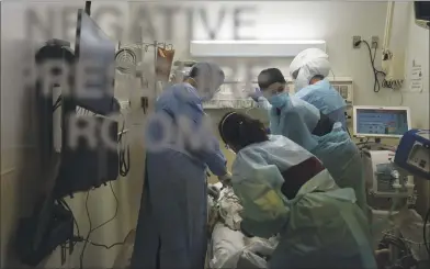  ?? JAE C. HONG — THE ASSOCIATED PRESS ?? EMT Giselle Dorgalli, second from right, looks at a monitor while performing chest compressio­n on a patient who tested positive for the coronaviru­s in the emergency room at Providence Holy Cross Medical Center in Los Angeles on Thursday.