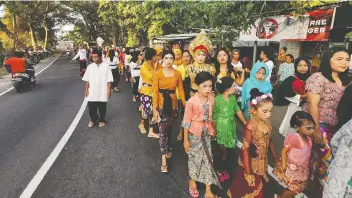  ??  ?? A wedding procession takes place in Lombok, Indonesia, where a new law bans child marriage.