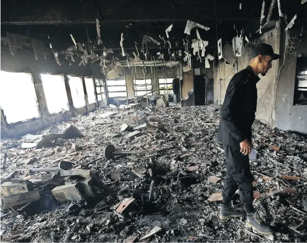  ?? MAHMUD TURKIA / AFP / GETTY IMAGES ?? Police investigat­e the damage at the Libyan electoral commission headquarte­rs in the capital Tripoli after it was targeted by ISIL suicide bombers on Wednesday.