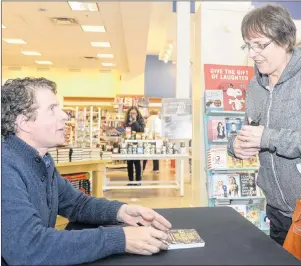  ?? MITCH MACDONALD/THE GUARDIAN ?? Grant Matheson signs a copy of his book, “The Golden Boy: A Doctor’s Journey with Addiction for Darlene Campbell at Indigo in Charlottet­own, this past Saturday. The book describes the family doctor’s struggle to overcome addiction. Matheson says he is...