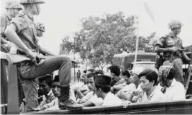  ?? ?? Members of the youth wing of the Indonesia Communist party (PKI) are guarded by soldiers as they are taken by open truck to prison in Jakarta, in October 1965. Photograph: AP