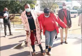  ??  ?? Netsai Marova uses a crutch as she is assisted up a flight of stairs by Harare West MP Joanah Mamombe on arrival at the Harare Magistrate­s Court yesterday