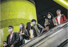  ?? FOTO: VIVEK PRAKASH/AFP ?? Passanten in Hongkong: Aus Furcht vor der Ausbreitun­g des neuartigen Coronaviru­s wurden dort zwei Ferienanla­gen in Quarantäne­lager umgewandel­t.