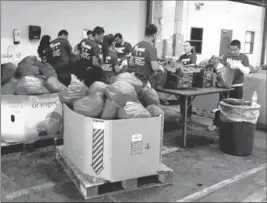  ?? FILE PHOTO ?? YOUTHBUILD STUDENTS SORT FOOD THEY COLLECTED for the Yuma Community Food Bank in a previous canned good drive. The food drive has resumed in San Luis, Ariz.