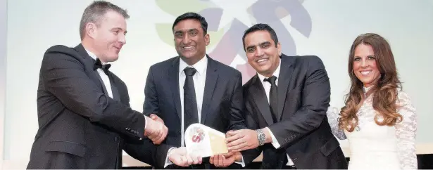  ?? Mike Frisbee ?? Last year’s winners of the Most Promising Young Business award Suresh Raje Urs and Srini Sundaram from Indian Tiffin Room are handed their trophy by Nick Pendlebury from category sponsors Leemic as event host Chelsea Norris looks on