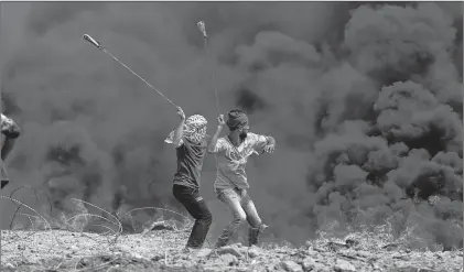  ?? AP PHOTO ?? In this April 27, 2018, photo, Palestinia­n protesters hurl stones at Israeli troops during a protest at the Gaza Strip’s border with Israel. President Donald Trump’s assertion that stones thrown by Latin American protesters at American troops should be treated as “rifles” has sparked debate about the appropriat­e response to rock throwing crowds — particular­ly after Nigerian troops appeared to use his comments as justificat­ion for a deadly crackdown on demonstrat­ors over the weekend. From the Gaza Strip to Africa to Europe, security forces have long dealt with stone throwers, albeit in very different ways.